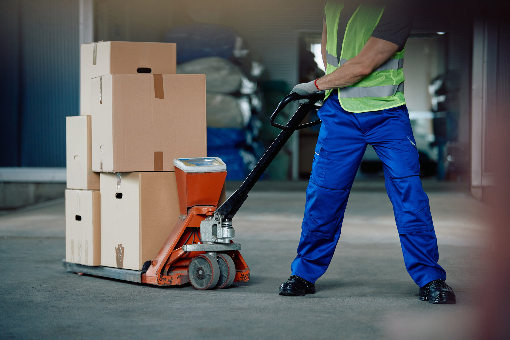 Ein Arbeiter schiebt eine Ameise mit Ware