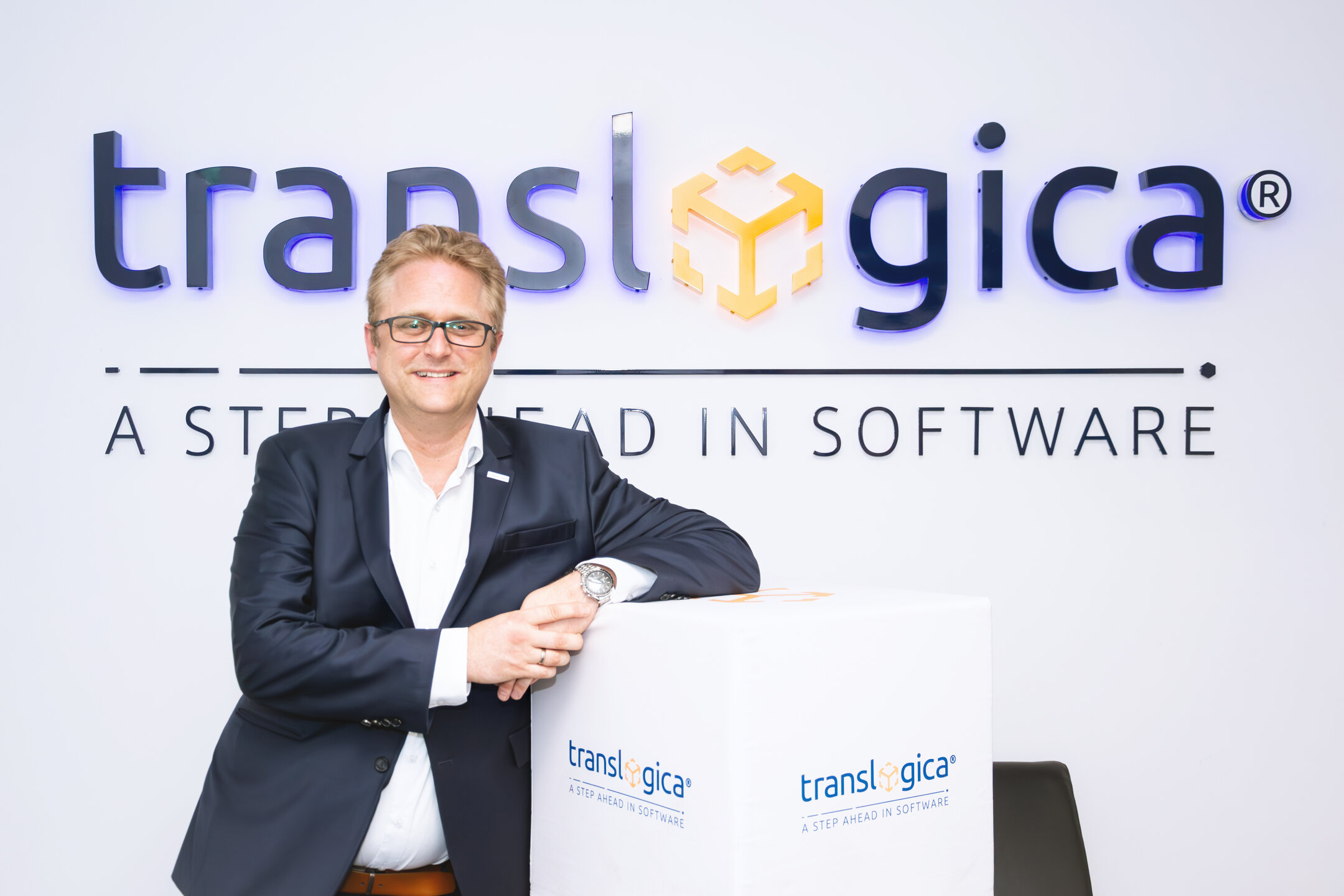Hansjörg Haller (CEO) translogica vor dem Firmenlogo